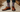 A picture of a well-dressed man from the calves downward where colorful dress socks and brown dress shows may be seen.